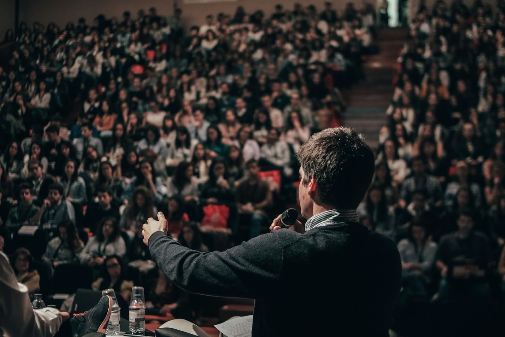 A speaker addressing a full room